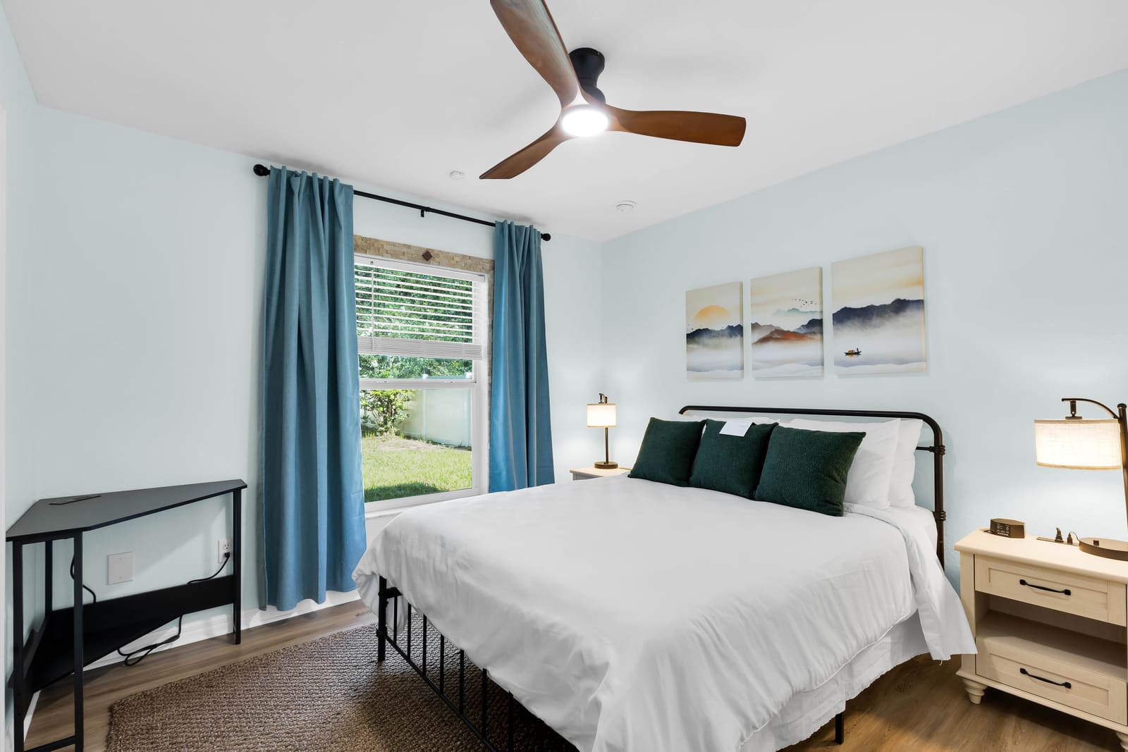 Second bedroom with queen bed and blue curtains