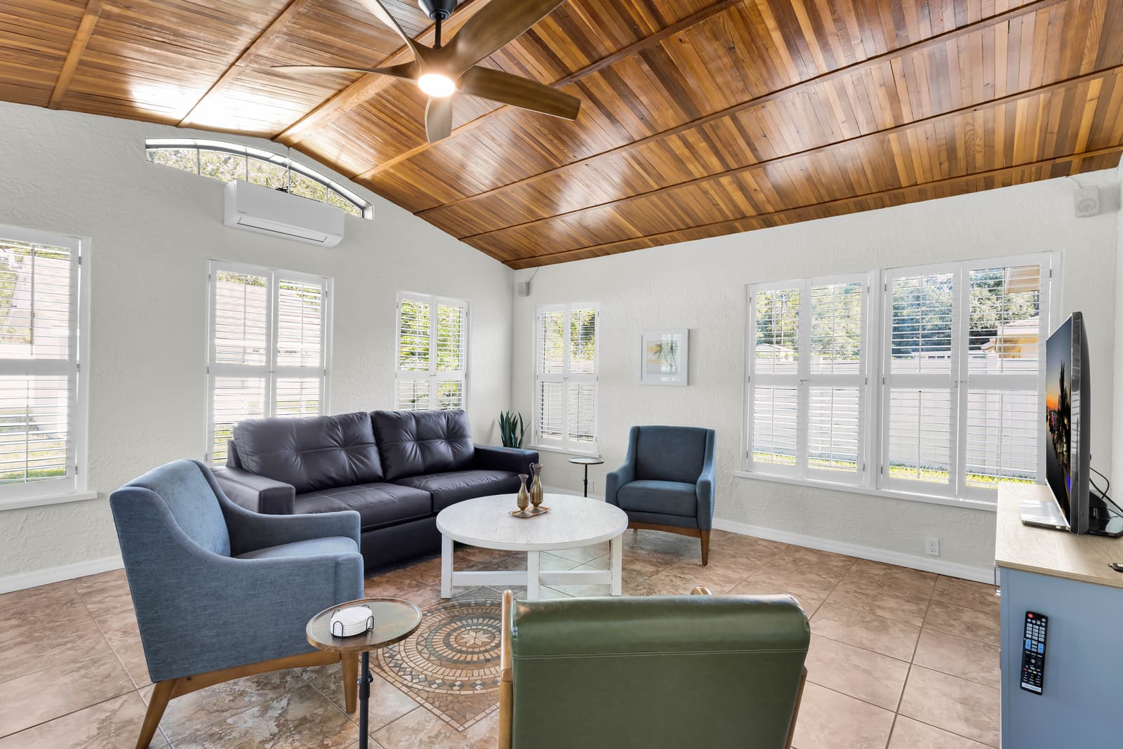Sunroom with wood ceiling, sofas, TV, and games